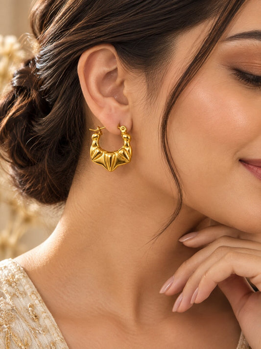 Golden sculpted statement hoop earrings with anti-tarnish finish for women, featuring a bold geometric design.