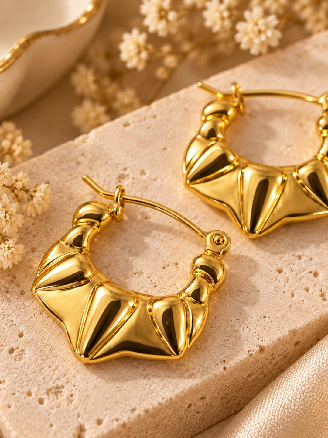 Golden sculpted statement hoop earrings with anti-tarnish finish for women, featuring a bold geometric design.