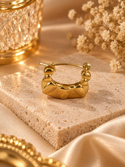 Golden sculpted statement hoop earrings with anti-tarnish finish for women, featuring a bold geometric design.