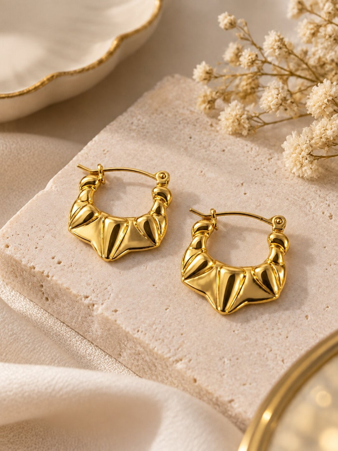 Golden sculpted statement hoop earrings with anti-tarnish finish for women, featuring a bold geometric design.